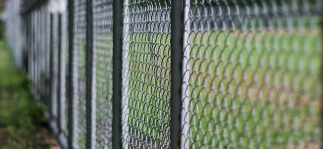 Chain,link,fence,with,green,trees,in,background, ,security Property protection perimeter security